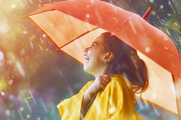 Mädchen im Regen mit einem Regenschirm